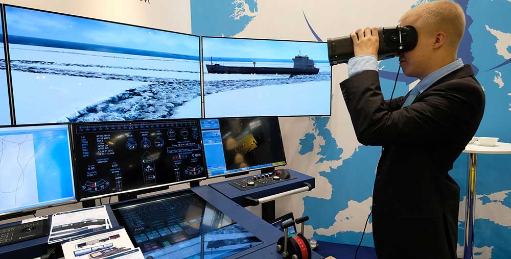 Man with VR glasses standing in front of a wall of monitors